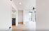 Bright and airy bedroom with floor-to-ceiling windows, ceiling fan, and a walk-in closet. Modern bathroom with stylish lighting visible through the open door.