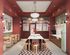 Charming retro kitchen featuring a mint green vintage fridge, vibrant red walls, and stylish dining nook with striped seating.