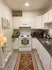 Charming kitchen with modern white cabinets, cozy lighting, and a stylish patterned runner rug.