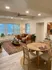 Elegant living space with modern decor, featuring a cozy sofa, stylish coffee table, and dining area with natural light.