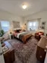 Inviting bedroom with warm earth tones, elegant decor, and plush furnishings complemented by a cozy, patterned rug.
