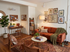 Charming living room with earthy tones featuring a cozy sofa, elegant decor, and a stylish workspace creating a warm and inviting atmosphere.