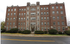 Charming historic brick apartment building with classic architecture, featuring lush landscaping and convenient urban location.