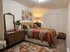 Inviting bedroom with warm earth tones, chic wooden furniture, and stylish wall art, creating a cozy and modern ambiance.