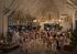 Lively event space filled with people enjoying a festive gathering under elegant chandeliers, featuring lush greenery and a bright, inviting ambiance.