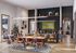 Vibrant community space featuring a modern kitchen island, cozy seating, and a lively atmosphere with people socializing and watching television.