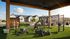 Vibrant outdoor fitness area with modern gym equipment, surrounded by lush greenery and stylish residential homes.
