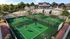Vibrant community space featuring tennis and pickleball courts, sand volleyball court, and luxurious amenities with people enjoying outdoor activities.