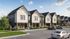 Charming townhouse community with modern architecture, lush landscaping, and convenient parking under a blue sky.