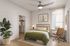Modern bedroom with cozy green bedding, large potted plant, walk-in closet, and sleek workstation by a sunlit window.