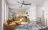Bright and stylish open-concept living area with elegant brown sofa, modern kitchen with wooden cabinetry, and chic decor accents in a spacious apartment.