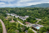 Charming apartment complex nestled in lush greenery with scenic mountain views, offering a tranquil living environment.