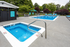 Inviting outdoor area featuring a sparkling pool and relaxing spa surrounded by lush greenery, perfect for leisure and entertainment.