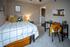 Bright, modern bedroom featuring a cozy bed with vibrant pillows, a functional workspace with a sleek desk, and ample natural light.