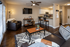 Chic, modern living room with stylish furnishings, open-concept kitchen with sleek countertop, and cozy seating area illuminated by contemporary lighting.