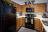 Charming kitchen with oak cabinetry, sleek black appliances, and cozy decor accents.