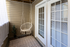 Charming balcony retreat with a cozy hanging chair, elegant curtains, and stylish flooring for ultimate relaxation.