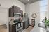 Modern kitchen with sleek stainless steel appliances, stylish dark wood cabinets, and elegant granite countertops, enhanced by natural light from large windows.