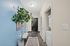 Chic apartment hallway with a modern design, featuring a bright blue accent wall, stylish potted plant, and convenient in-unit laundry space.
