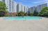 Modern apartment complex with a stunning outdoor pool surrounded by lush greenery and sun loungers, perfect for relaxation.