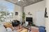 Bright and modern living room with large windows, chic decor, cozy seating, and a stylish entertainment setup.