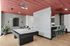 Modern recreational room with a stylish pool table, chic red ceiling, and an inviting bar area with sleek seating.