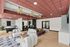 Modern communal space with sleek seating, vibrant red ceiling, stylish lighting, and an inviting bar area, perfect for relaxation and social gatherings.