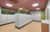 Modern apartment mailroom featuring stylish mailboxes, lush greenery accents, and a sleek wooden floor.
