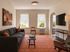 Inviting living room with a modern sofa, stylish artwork, and large windows offering ample natural light.