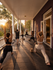 Serene yoga session on a spacious veranda, bathed in warm sunset light, with lush greenery in the background.