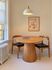 Cozy dining nook with a round wooden table, two stylish chairs, and elegant pendant lighting, perfect for intimate meals.