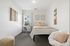 Bright, cozy bedroom with modern decor, plush seating, and a large window for natural light.