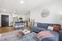 Bright, modern living space with sleek kitchen, cozy gray sofa, and chic decor.