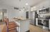 Modern kitchen with sleek stainless steel appliances, pendant lighting, and a stylish breakfast bar with seating.