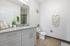 Elegant bathroom featuring a sleek modern vanity, stylish wall art, and lush green accents for a refreshing ambiance.