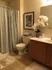 A cozy bathroom in The Villas of Castleton, equipped with a toilet, shower curtain, and a sink for convenience.