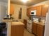 A kitchen at The Villas of Castleton featuring a refrigerator, stove, and microwave, designed for convenience and comfort.
