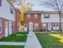 Two-story brick townhouse at Catons Villas South with white trim, maroon shutters, sidewalk, lawns, and autumn trees.