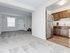 Cozy minimalist apartment at Catons Villas South with light gray carpet, dark wood kitchen cabinets, stainless appliances, and open floor plan.