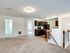 Unit with wall-to-wall carpeting, stairs downstairs, and a kitchen