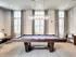 A Union Flats billiard table in a cozy room with a couch and chairs, inviting for a game or relaxation.