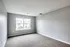 Empty room with gray walls and carpeting at The Villas of Castleton, creating a calm and neutral atmosphere.