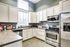 The Villas of Castleton clubhouse kitchen showcases stainless steel appliances paired with elegant white cabinetry.