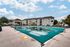 The inviting pool at The Villas of Castleton is surrounded by greenery and lounge seating.