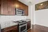 Stainless steal appliances with dark wood cabinets and lite gray granite