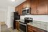 Stainless steal appliances with dark wood cabinets and lite gray granite