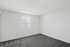 Empty room at Catons Villas South with gray carpet, white walls, single window, and clean, minimalist, spacious feel.