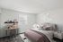 Cozy bedroom at Catons Villas South with soft pink bed, crescent moon light, small desk with red lamp, and large window.