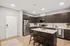 A modern kitchen with sleek stainless steel appliances and warm wood floors creates a stylish and inviting atmosphere in a two bedroom at Lofts at Yard 56.