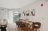 A stylish modern apartment featuring a sleek dining table surrounded by elegant chairs, perfect for gatherings at Lofts at Yard 56.